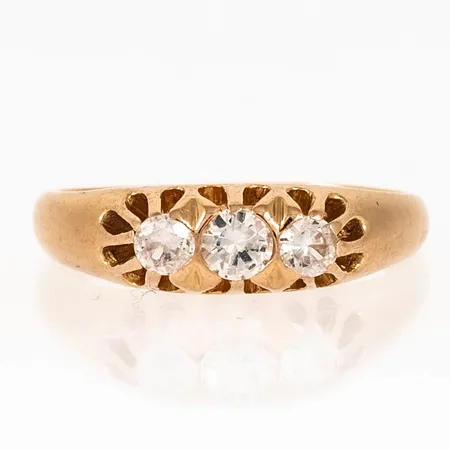 Doserad ring i 18K guld med tre vita stenar i klofattning. Den är i storlek 17, är 1,6 - 5,4 mm bred och väger 3,7g. 18K & Kattfot. Slitna klor. Naggade stenar.  