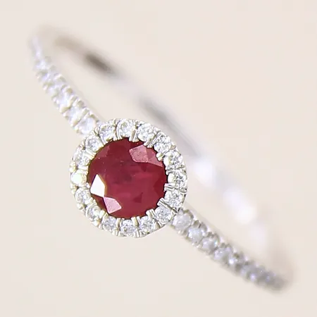 Ring med troligen en röd rubin samt diamanter 34 x ca 0,005ct, stl: 18, bredd: 1,2-6,5mm, GHA, vitguld, 18K  Vikt: 2 g