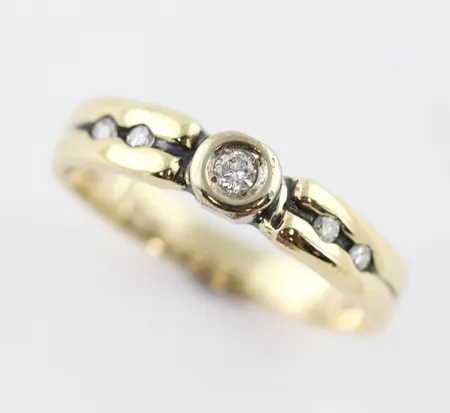 Ring med diamanter enligt inskription 0,15ct, stl 18¼mm inte helt rund, bredd ca 3-4,5 mm, stämplad GFAB, 18k Vikt: 2,9 g