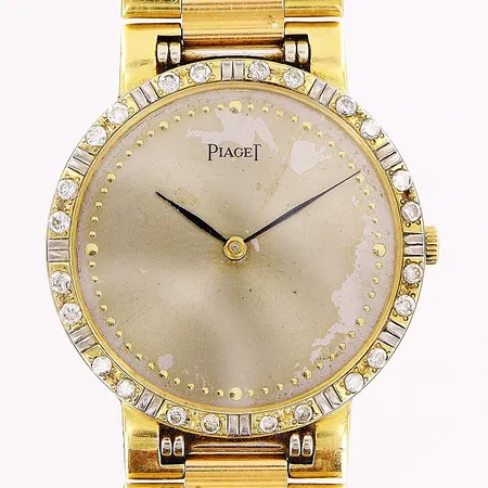 Herrur Piaget, 18K, quartz, Ø32mm, fuktskadad/fläckig urtavla, diamanter på glasring 24 x ca 0,02ct, briljantslipade, integrerad länk gul/vitguld 18K, 20cm, klockan fungerar ej/eventuellt batteribyte, mindre hack/repor på boett, bruttovikt 85g, inga tillbehör. 