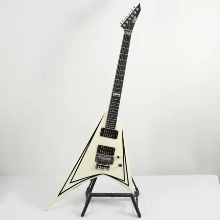 Gitarr ESP vit med svarta stripes, lackskada på ena vingen, hardcase (hardcaset med tejplagningar). Vikt: 0 g Skickas med Bussgods eller PostNord