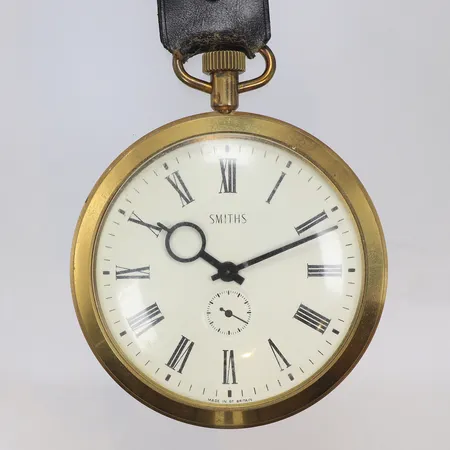 Fickur Smiths Ø88mm, s.k. Goliath-fickur, troligen i reklamsyfte, gulmetall, manuell uppdragning, omkring 1900-talets mitt, romersk urtavla, detalj i läder, smärre slitage 