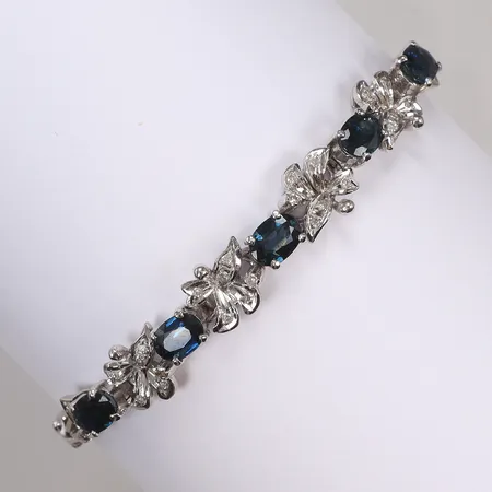 Armband i vitguld med slipade blå stenar samt diamanter 26xca0,005-0,01ct, längd ca 18,5-19cm, säkerhetskedja, bredd 4-8mm, otydliga stämplar, håller 14K Vikt: 14,1 g
