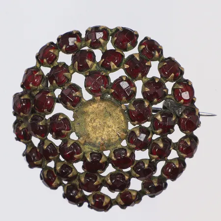Brosch i gulmetall med röda stenar, möjligen granater (saknar mittsten) Ø30mm, 1900-talets första hälft 