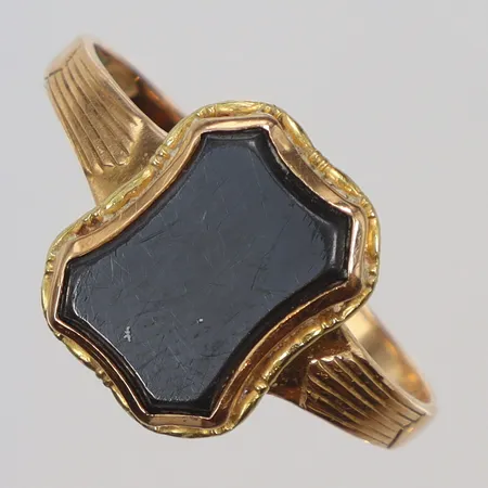 Klackring med grå sten, möjligen onyx stl 21¾ bredd 2-14mm, gravyr, skev 18K Vikt: 4,8 g