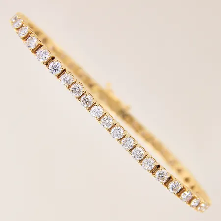 Armband, rivière, med briljantslipade diamanter 44 x ca 0,12ct, kvalitet ca Ca-Cr (J-K)/P-SI, fyra stycken av diamanterna indikerar på att vara syntetiska, längd 16,5cm, bredd 3,5mm, mindre ojämnheter, 18K  Vikt: 17,6 g