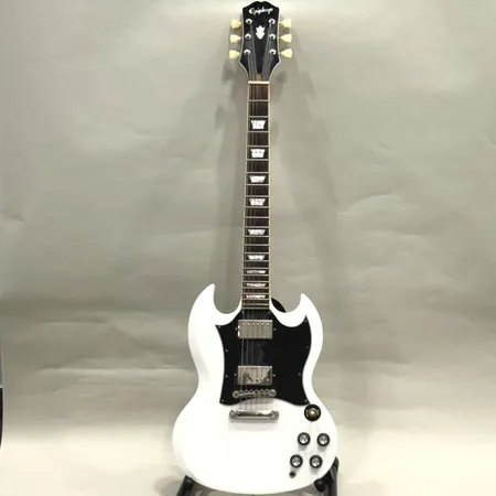 Elgitarr Epiphone SG Standard Alpine Eagle serie-nr: 20021528544, bruksslitage, dammig/fläckig, repig, sprakar endast vid inkoppling till förstärkare, i behov av översyn samt justering, ena micken troligen defekt, mjukt fodral med slitage Skickas med Bussgods eller PostNord