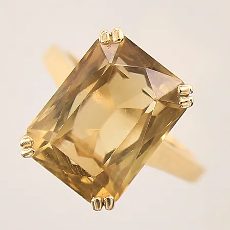 Ring med gul sten, troligen citrin, stl 19¼, bredd 2-16mm, ostämplad, sten med flertal mindre nagg på fasetterna, 18K  Vikt: 8,6 g