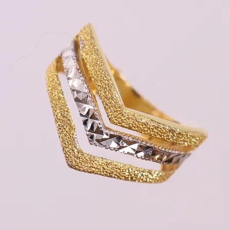 Ring med arbetad yta, stl: 17¾, bredd 4-11mm, vit/gult guld 18K.  Vikt: 4,6 g