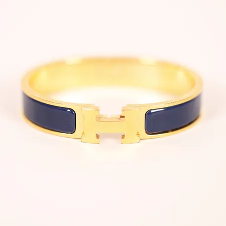 Armband, Hermès Clic Clac, guldfärgad metall med mörkblå emalj, ca 55x45mm, bredd 11,5mm, numrerad FI0134, bruksslitage, dustbag, etui,   