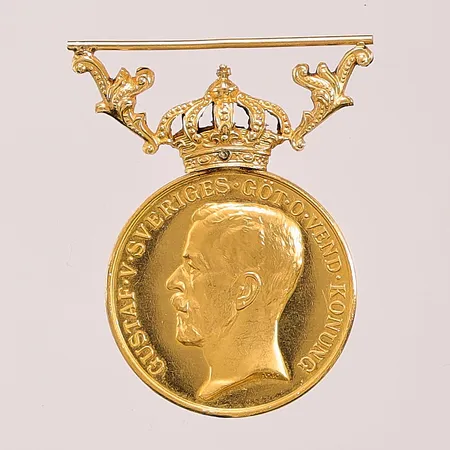 Medalj, krona i 18K, gravyr, 23K bruttovikt 12,5g.