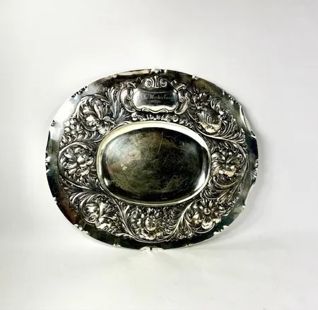 Fat med ciselerad dekor, GAB, I8/1935, ovalt, 40x47 cm, personlig gravyr på framsida, större buckla på höger kant, 830/1000 silver. Vikt: 1039 g Skickas med postpaket.