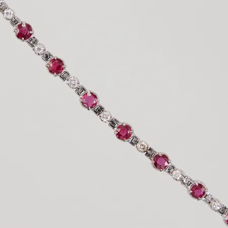 Armband, 17,5cm, 14st diamanter totalt 0,70ctv ca TW(G)/SI, samt 14 behandlade rubiner, bredd ca 3,3 - 5,2mm, kvitto från Kaplans år 2008, ostämplad vitguld, 14K,  Vikt: 10,6 g