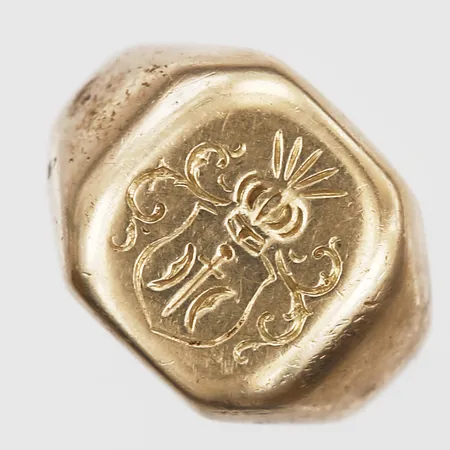 Klackring med vapenmonogram, stl: 18¾, bredd: 5 -15mm, slitage, 18K guld. Vikt: 13,2 g