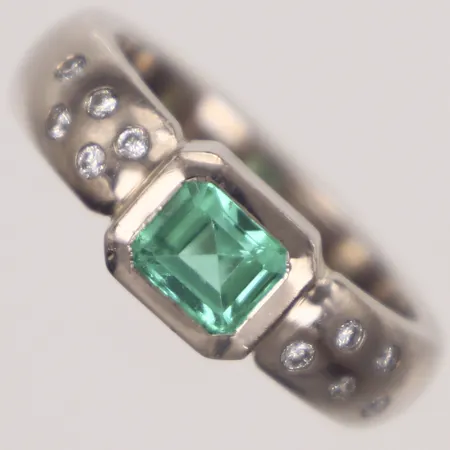 Ring med troligen smaragd ca 4,8x6mm och briljantslipade diamanter ca 0,20ctv, stl 18, bredd 5,3mm, Stjernswärd Juveler, Stockholm, år 2000, vitguld, ytslitage på smaragd, 18K  Vikt: 12,9 g
