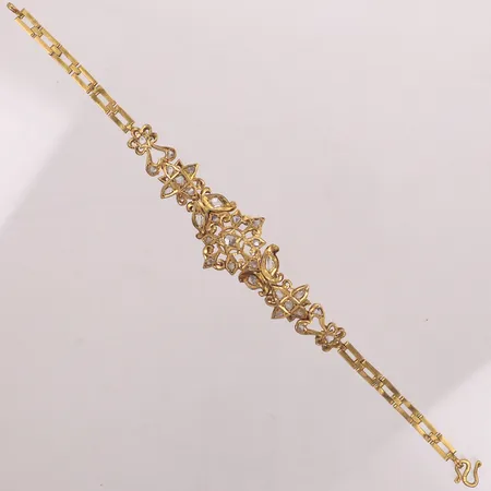 Armband med vita stenar, längd 18,5cm, bredd 4,3-21,4mm, s-lås troligen högre guldhalt, ostämplat, bucklor, 18K  Vikt: 15 g