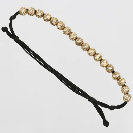 Armband med guldkulor samt nylonband, innermått 18,5 - 12 cm, 14K guld. Bruttovikt: 3,2g Vikt: 3,2 g