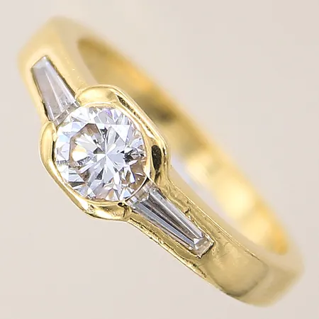 Ring med diamanter 1xca0,65ct ca TCr(I)/Si2, trapetsslipade 2xca0,15ct, stl: 16¾, bredd: 2,2-6,3mm, 18K Vikt: 4,7 g