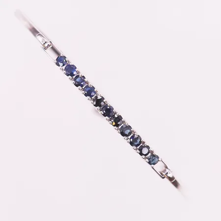 Armring, öppningsbar, med mörkblå safirer, 11 x ca 0,05ct, innermått 58mm, 18K vitguld Vikt: 5,6 g