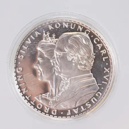 Minnesmynt till minne av Kung Carl XVI Gustaf & Drottning Silvias silverbröllop 2001. Nominellt värde 200kr. Ø 36 mm. 27,0g 925/1000 silver. I etuier med infoblad