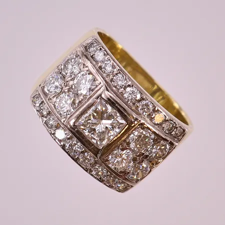 Ring med prinsesslipad diamant 1 x ca 0,75ct, briljantslipade diamanter 6 x ca 0,16ct, 2 x ca 0,12ct, 18 x ca 0,02ct, totalt ca 2,30ctv, ca W(H)/VS-SI, en 0,16ct med fjäder som når ytan, fåtalet av de mindre diamanter indikerar på syntetiska, stl: 17½, bredd 10-13mm, fattning i vitguld, David Batchelor, Sydafrika, enligt uppgift tidigt 1990-tal, gravyr, 18K.   Vikt: 13,3 g
