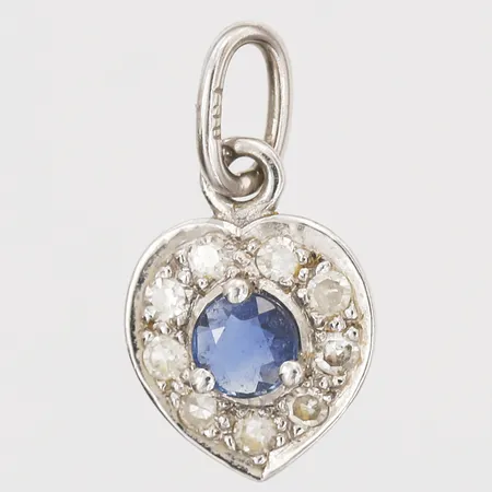 Hänge i form av ett hjärta med safir 0,20ct samt briljantslipade diamanter, totalt 0,13ct, kvalitet  W(H)/P1, vikter samt kvalitet enligt certifikat/garantikort från Bröderna Hedéns guldsmeds AB,  daterat 3 april 1982, höjd 14mm, 18K vitguld Vikt: 0,8 g