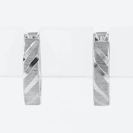Creoler i 14K vitguld. Ovala matterade med blanka diagonala linjer. Mått 12 x 14 mm, bredd 3,2 mm. Väger 1,3g.