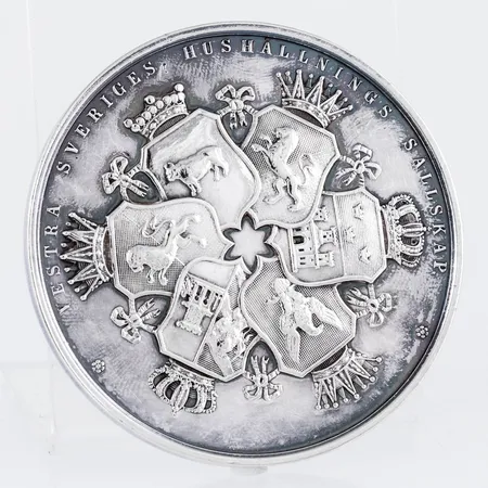 Medalj i silver Ø 51,3 mm. "BELÖNINGSMEDALJ VID VESTRA SVERIGES LANDTBRUKSMÖTE I (JÖNKÖPING är graverat)", "VESTRA SVERIGES HUSHÅLLNINGS SÄLLSKAP". Vikt: 55,0g.