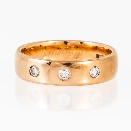Ring i 18K guld med 3 x 0,05ct briljantslipade diamanter i lordfattning. Den är i storlek 17, är 4,8 mm bred och väger 5,4g. Stämplad GBA (Guldbolaget, Bergkvara), Stenstorlek, 18K & Kattfot. Gravyr.