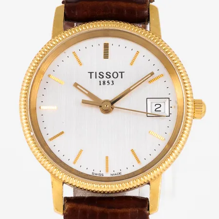 Damur Tissot i 18K guld med pärlkant, brunt läderband. Boett Ø 24 mm med gravyr "För nit...". Datum. Safirglas. Quartz- går ej- batteribyte krävs? Vikt: 0 g