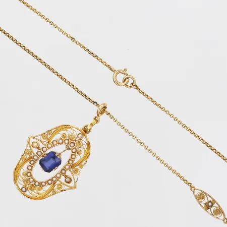 Kedja och hänge med filigranarbete samt seedpärlor, Guldvaruaktiebolaget G. Dahlgren & Co, Malmö 1919, kedja längd: 54cm, kedja bredd: 1-5,5mm, en syntetisk safir ca. 0,75ct, hänge höjd inkl. ögla: 44mm, hänge bredd: 25mm, 18K guld. Vikt: 11,2 g