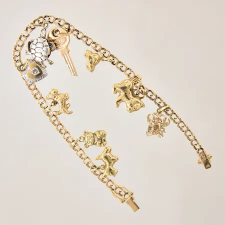Armband Bismarck med 9 berlocker, längd 18,5cm, bredd 3,6-10mm, en berlock i silver, 18K  Vikt: 10,7 g