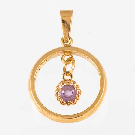 Hänge i 18K guld: Hängande berlock i ring med ljuslila sten. Den är mm bred, mm lång inkl. ögla och väger 5,2g. Stämplad M9 (1962), UGG (Guld & Gravyr, Ivar Öhman, Umeå), 18K & kattfot.
