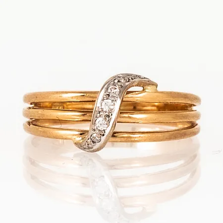 Doserad ring i 18K guld. Dekor i vitguld med fem vita stenar. Den är i storlek 17½, är 3 - 8,5 mm bred och väger 2,8g. Stämplad 750. 