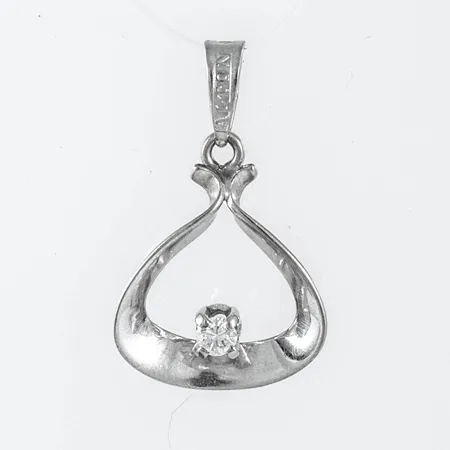 Hänge i 18K vitguld med en briljantslipad diamant ca 0,04ct. Den är 11,7 mm bred, 19,4 mm lång inkl. ögla och väger 0,7g. Stämplad ALTON, 18K & kattfot.