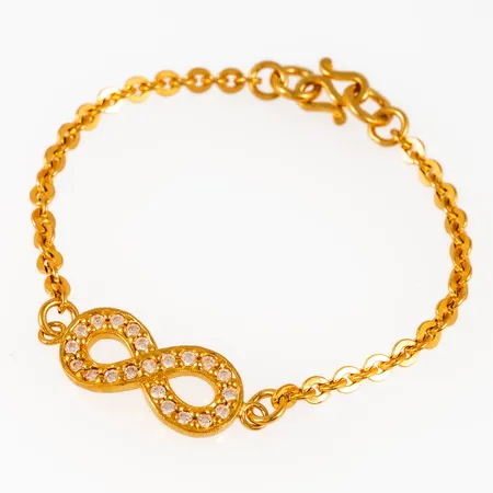 Armband i 23K guld: Evighetstecken med vita stenar. Det är 16,5 cm långt, 3,2 - 10,5 mm brett och väger 7,6g (½ baht) Thaiguld.