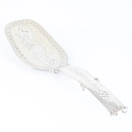 Tårtspade i silver (830/1000) med handgraverat samemotiv. Den är 19,5 cm lång och väger 53g. 1944 av Göte Persson i Vilhelmina. 