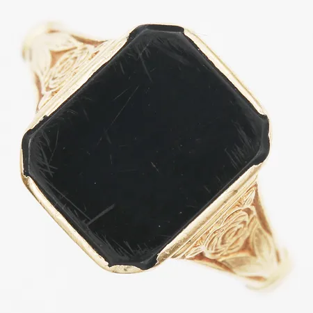 Klackring med onyx samt dekor i relief, stl: 17½, bredd: 3 - 13 mm, gravyr, slitage på sten, 18K guld. Vikt: 3,8 g