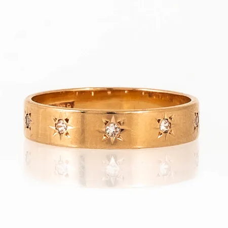 Ring i 18K guld med fem vita stenar fattade i stjärnstick. Den är i storlek 18, är 4 - 4,4 mm bred och väger 3,2g. Stämplad U9, BKG, 18K & kattfot. 