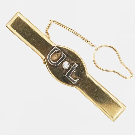Slipsnål med diamant 1 x ca. 0,04ct, längd: 6cm, bredd: 8-14mm, säkerhetskedja, Silversmedjan i Perstorp AB, Klippan 1994, gravyr, nagg på sten, 18K vitguld/rödguld. Vikt: 14,3 g