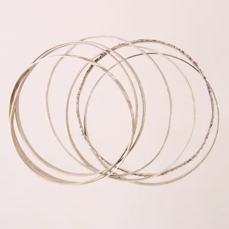 Sju stela armringar med mönsterdekor, inre bredd ca 67mm, bredd ca 2-3,6mm, skeva/ojämna, Silver 925/1000  Vikt: 32,5 g