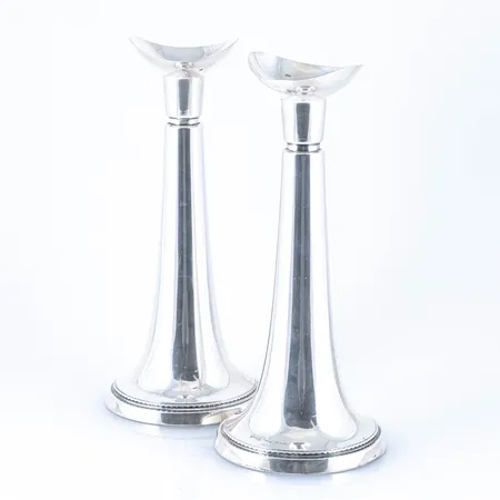 Ett par ljusstakar i silver (925/1000). De är 20,5 cm höga och väger 885g brutto tillsammans. Fyllda fötter ända upp till dekorranden under ljushållarna. Stämplade CGH, kattfot, S, K9 (1960), STERLING. 