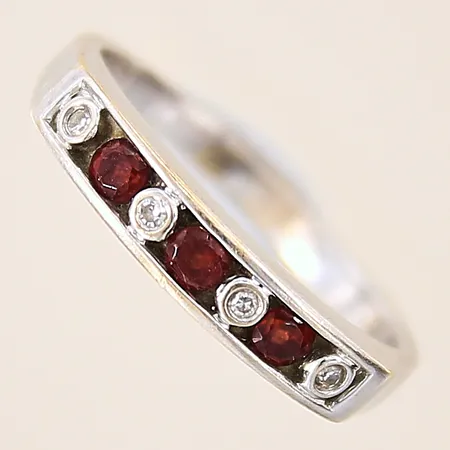 Ring med röda stenar samt diamanter 4 x ca 0,01ct, stl 16½, bredd 2-3,6mm, nagg på stenar, vitguld, 18K Vikt: 3,4 g