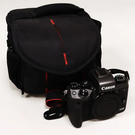 Kanerahus Canon EOS M5, serie nr 313051000196, objektiv Canon 15-456mm IS, serie nr 471208001782 påsittande filter Kenko smart MC UV370 slim, 2 batteri Canon, batteriladdare Canon modell LC-E17E med nätsladd, väska Hama.
