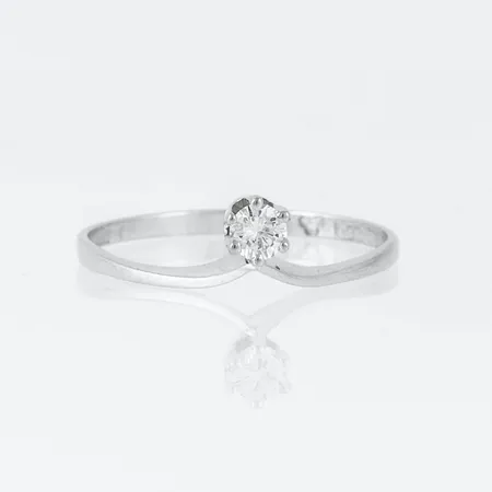 Ring i 18K vitguld med 1 x ca 0,15 ct briljantslipad diamant. Den är i storlek 18¼, är 1,6 - 6 mm bred och väger 1,6g. Stämplad X9 (1972), ALTON, 18K & kattfot. 