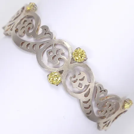Armband med gula syntetiska stenar, ca 56x42mm, bredd 14-18mm, ostämplat silver  Vikt: 12,8 g