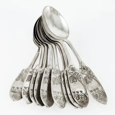 Tornedal i silver (830/1000): tio kaffeskedar med handgraverad dekor. De är 12 cm långa och väger 124,4g tillsammans. Nio från CO Persson i Haparanda, en från Strömbergs Eftr i Haparanda. Bruksskick. 