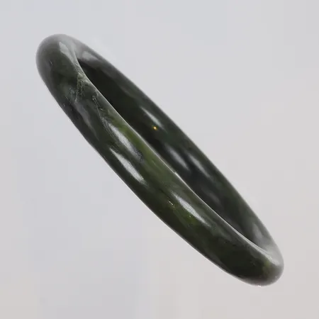 Armring i grön sten,  troligen i jade eller nefrit, Ø64mm innermått, bredd 10mm, 