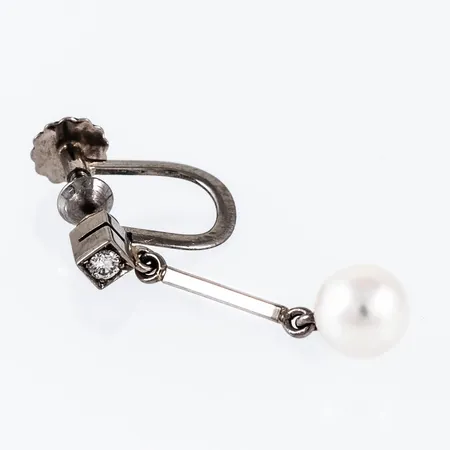 Ett udda örhänge i 18K vitguld med en odlad vit pärla Ø 6 mm och en briljantslipad diamant ca 0,03ct. Det är 1,1 - 6 mm brett, 24 mm långt och väger 1,5g. Stämplad I9, GVH, 18K & kattfot. Skruvmekanik. 