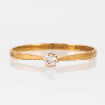 Ring i 18K guld med 1 x 0,07ct briljantslipad diamant. Den är i storlek 18, är 1 - 1,6 mm bred och väger 1,1g. 18K & kattfot. Stenstorlek 0,07ct ingraverat. 